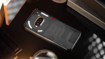 Le Nothing Phone (2a) posé face contre terre et vu de haut avec les LED de son interface Glyphe allumées