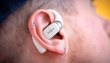 Gros plan sur des écouteurs sans fil Shokz OpenFit 2 reposant dans une oreille.