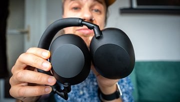 Eine Person hält Sony WH-1000XM6 Kopfhörer und zeigt die Ohrmuscheln und den Bügel.